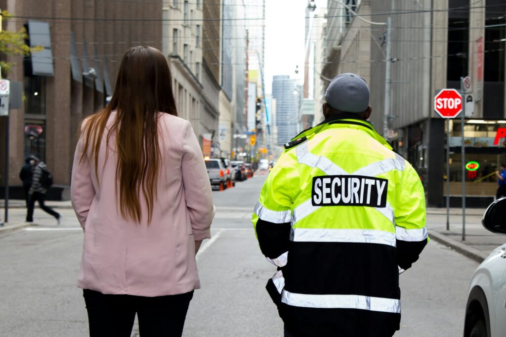 Closeup shot of a team of a security guard in uniform and a lady in suit patrolling the street